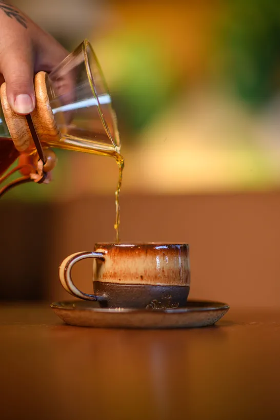 Café sendo servido na xícara de cerâmica