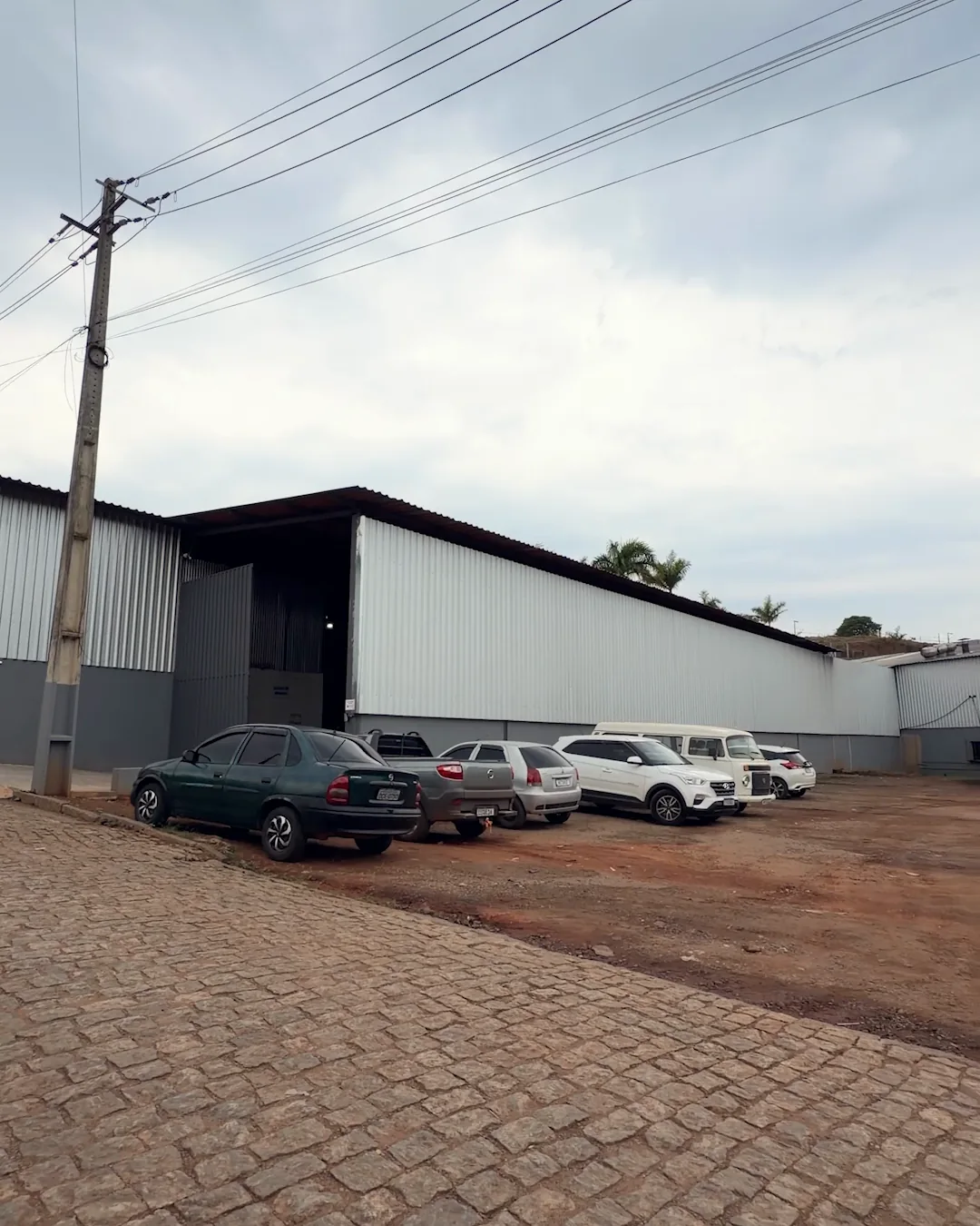 Galpão da Realiza em Elói Mendes visto de fora, com o estacionamento na frente