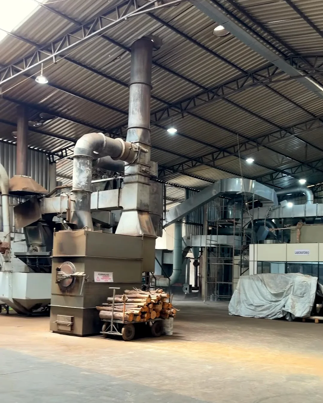 Galpão da fábrica da Realiza, com o torrador e os silos ao fundo
