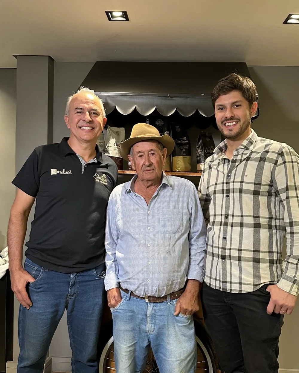 Três gerações da família diante da estante de cafés São Lucas